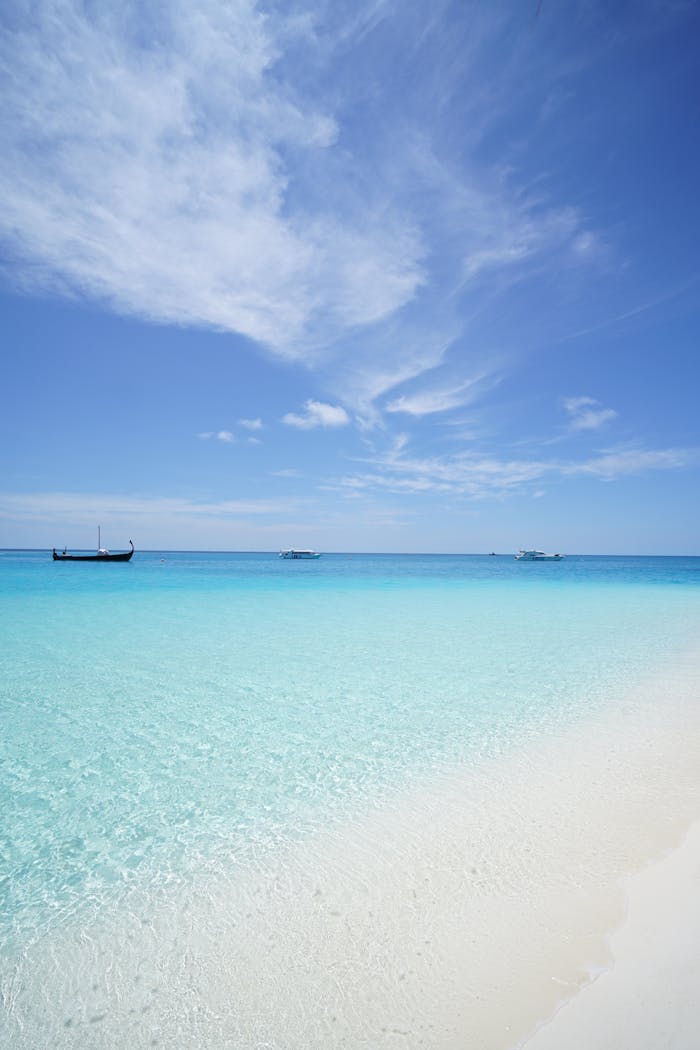 Peaceful beach scene with crystal clear waters and a deep blue sky, ideal for travel inspiration.