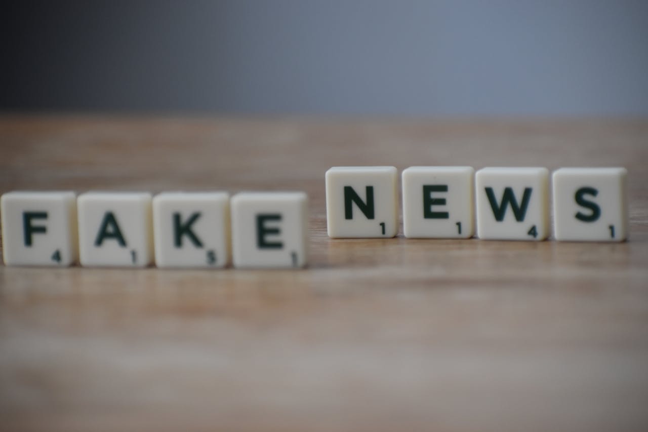 Scrabble tiles spelling 'Fake News' on a wooden surface highlighting misinformation.